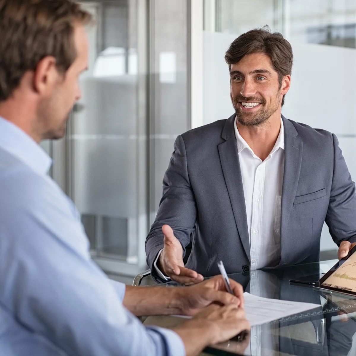 Asesoría en gestión de talento y recursos humanos – People Care México Consultor mostrando gráficos en tablet durante reunión – consultoría en recursos humanos para empresas en México